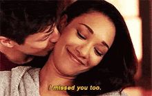 a man is kissing a woman on the cheek while she smiles and says `` i missed you too '' .