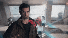 a man is holding a red butterfly in front of a broken glass