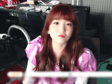 a girl with red hair is sitting in front of a computer monitor