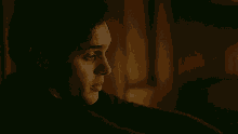 a close up of a man 's face in a dark room with a blurred background .
