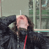a man smoking a cigarette with a lanyard around his neck that says ' tpb ' on it