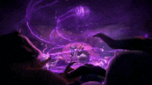 a crowd of people watching a show with purple lights coming out of the ceiling