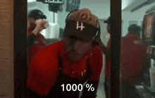 a man wearing a hat and visor is standing in front of a window in a fast food restaurant .