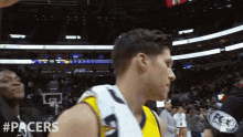 a basketball player with a towel around his neck and the word pacers on the bottom right