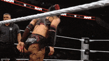 a woman in a wrestling ring with the word raw on the banner