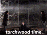 a group of people standing in front of a wall with the words torchwood time written on the bottom