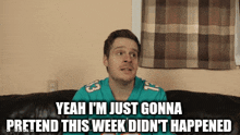a man sitting on a couch with the words yeah i 'm just gonna pretend this week did n't happen