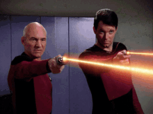two men are pointing lasers at each other while wearing red uniforms