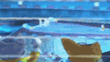 a blurred image of a cartoon character playing a video game in a blue room .