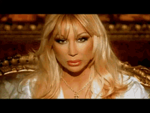 a woman with blonde hair and a gold chain around her neck