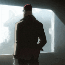 a man wearing a red hat and glasses looks out a window