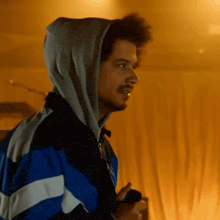 a man wearing a blue and white jacket with a hood on