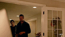 a man and a woman are standing in a living room