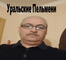 a man with glasses and a mustache is standing in front of a wall that says uralskie pelmeni