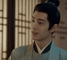 a man with a bun on his head is wearing a kimono