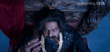 a man with a beard is sitting on a throne holding a cigar in his hand