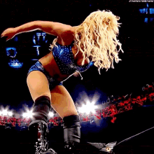 a female wrestler is upside down in a wrestling ring while a referee watches .