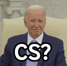 a man in a suit and tie is sitting in a chair with a cs sticker on his face
