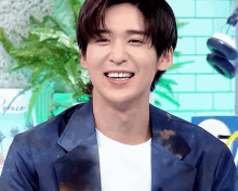 a young man wearing a blue jacket and white shirt smiles