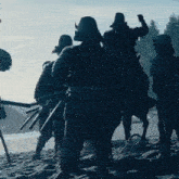 a group of soldiers standing on top of a sandy hill .
