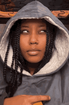 a woman with braids wearing a hooded jacket