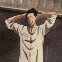 a man in a white shirt is standing with his hands behind his head and his eyes closed .