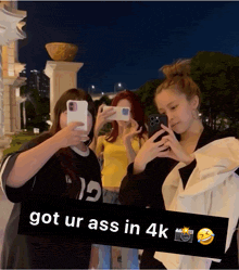 three girls are taking a picture with their cell phones with the caption " got ur ass in 4k "