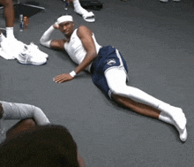a man laying on the floor with his legs crossed and a headband on his head