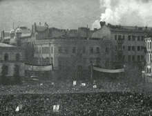 a large crowd of people are gathered in front of a building with a banner that says ' a ' on it