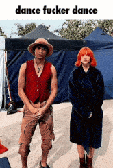 a man in a hat and a woman in a robe are standing next to each other .