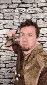 a man standing in front of a stone wall with bonk rompus lebron written on the top