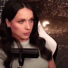 a woman is sitting in front of a microphone and making a face .