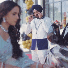 a man wearing a turban and sunglasses talks on a cell phone