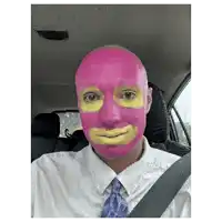 a man with his face painted pink and yellow is sitting in a car