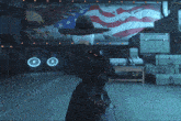 a woman in a cowboy hat stands in front of an american flag