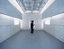 a man in a top hat is standing in a room with a lot of squares on the walls