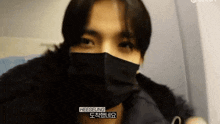 a close up of a person wearing a mask with the name heeseung written on the bottom