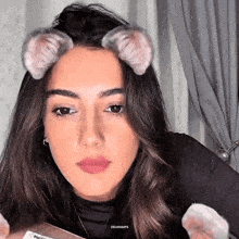 a close up of a woman wearing cat ears on her face .