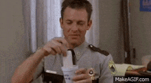 a man in a police uniform is holding a cup of ice cream in his hand .