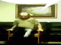 a man is sitting in a chair in front of a framed picture on the wall
