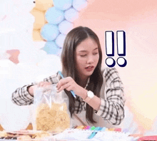 a woman is holding a bag of chips and a pencil .