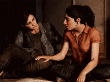 two women are sitting on the floor looking at each other and one is holding the other 's hand .
