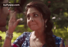 a woman is covering her face with her hands while making a funny face .