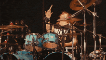 a man playing drums wearing a shirt that says raza