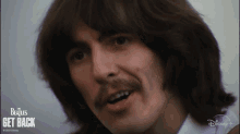 a close up of a man 's face with the beatles get back written on the bottom right