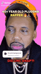 a man with a beard is wearing an orange hat and a black hoodie