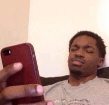 a man is laying on a couch looking at his phone .