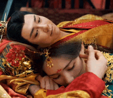 a man and a woman are laying on a bed and the woman is touching the man 's face .