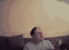 a man is sitting on a couch with his head in his hands