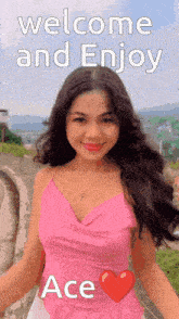 a woman in a pink top is standing in front of a sign that says " welcome and enjoy ace "